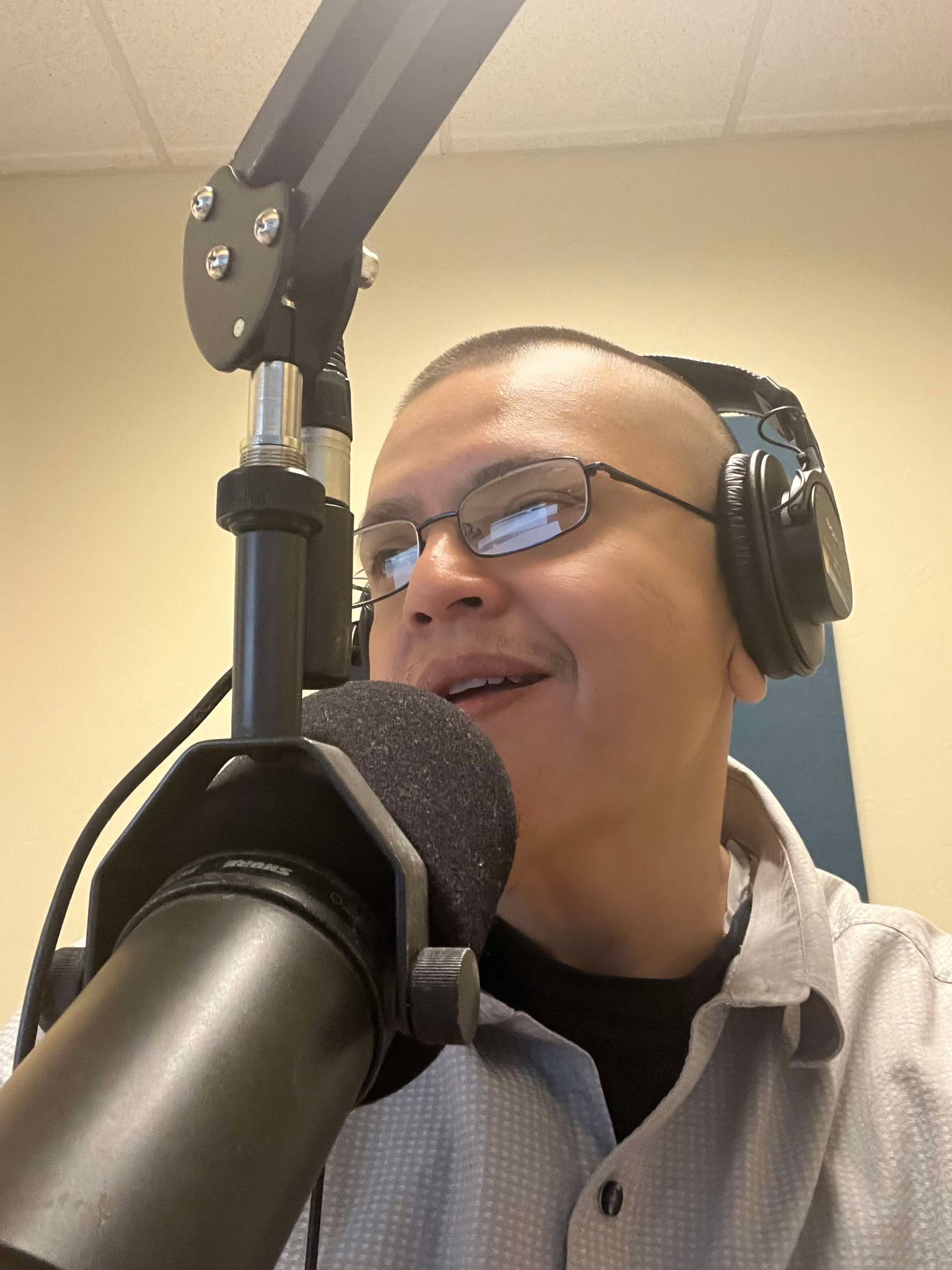 Mucho M. Martinez at a broadcast microphone wearing headphones
